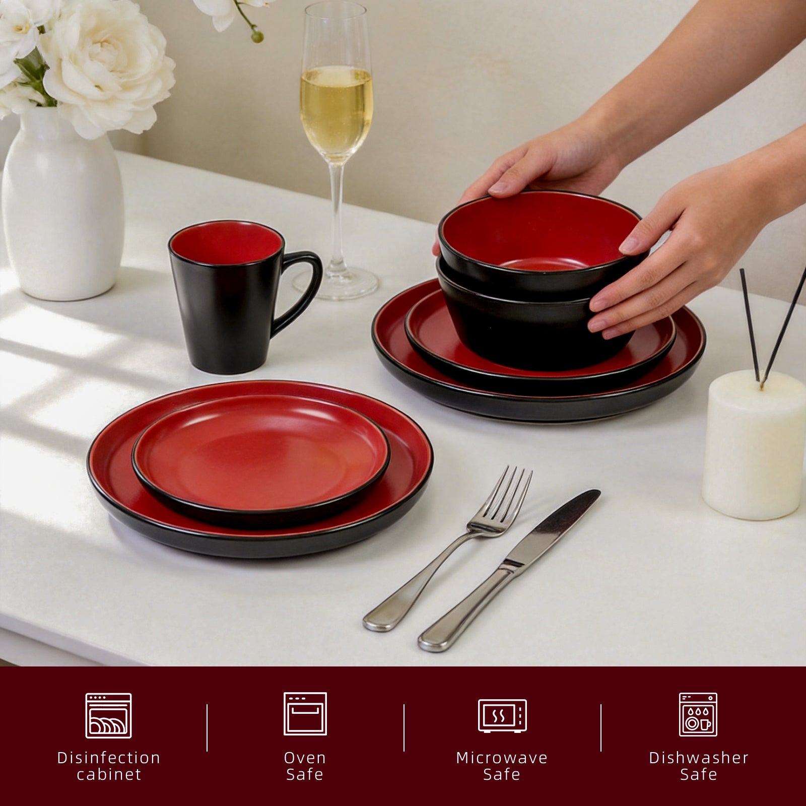 Red and black ceramic dinnerware set on a table with cutlery and a glass of wine.
