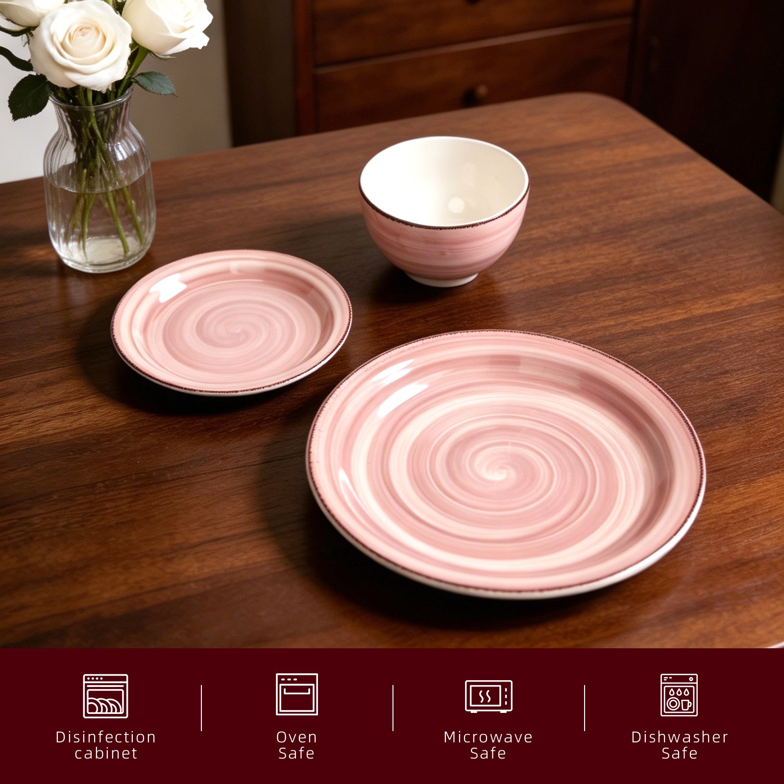 A pink and white spiral-patterned dinnerware set on a dark wooden table, featuring a large plate, a smaller plate, and a bowl. A glass vase with white roses sits on the left.