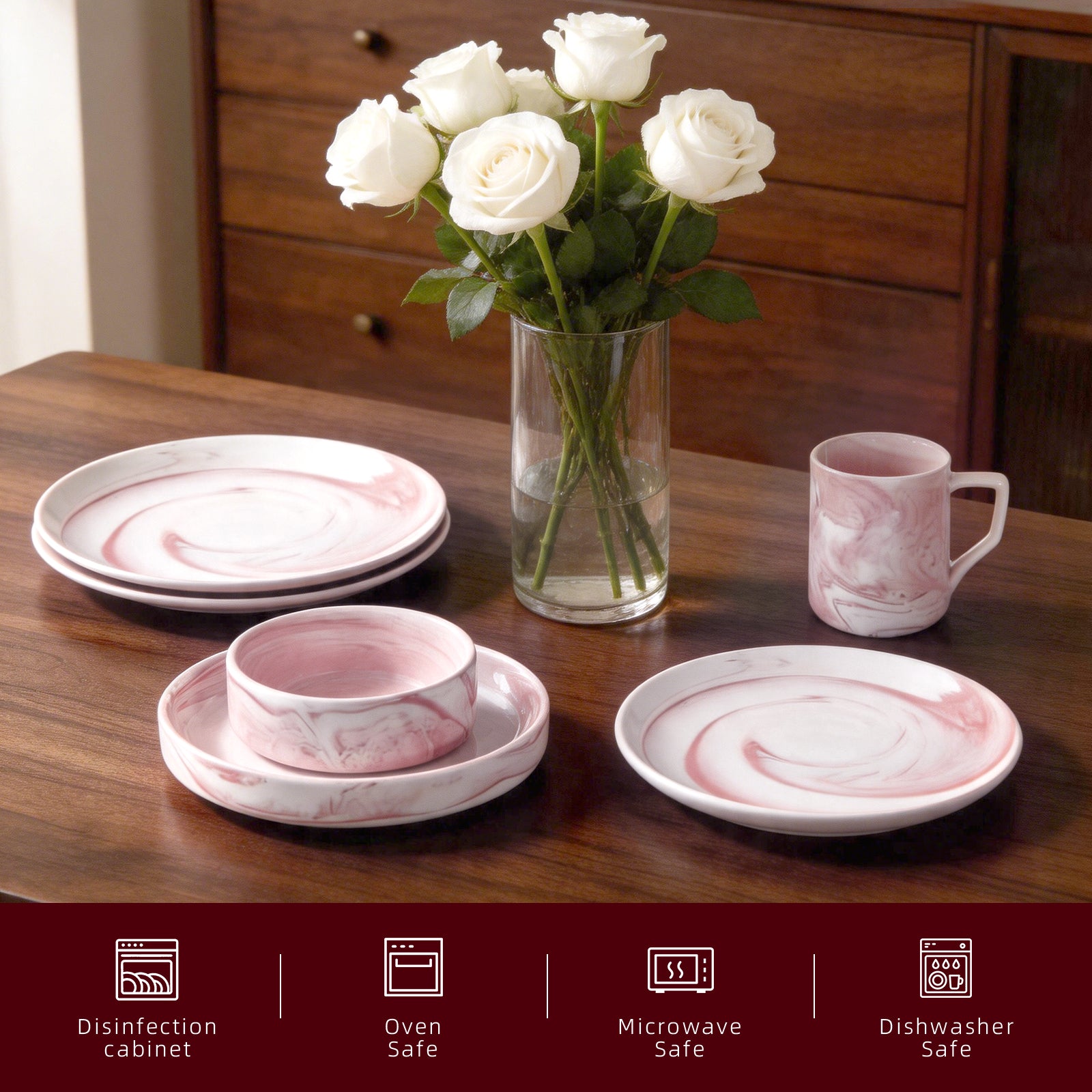 A pink and white marble-patterned dinnerware set on a wooden table, including plates, a bowl on a saucer, a mug, and a vase of white roses. A dark red banner at the bottom lists features such as disinfection cabinet compatibility, oven safe, microwave safe, and dishwasher safe.