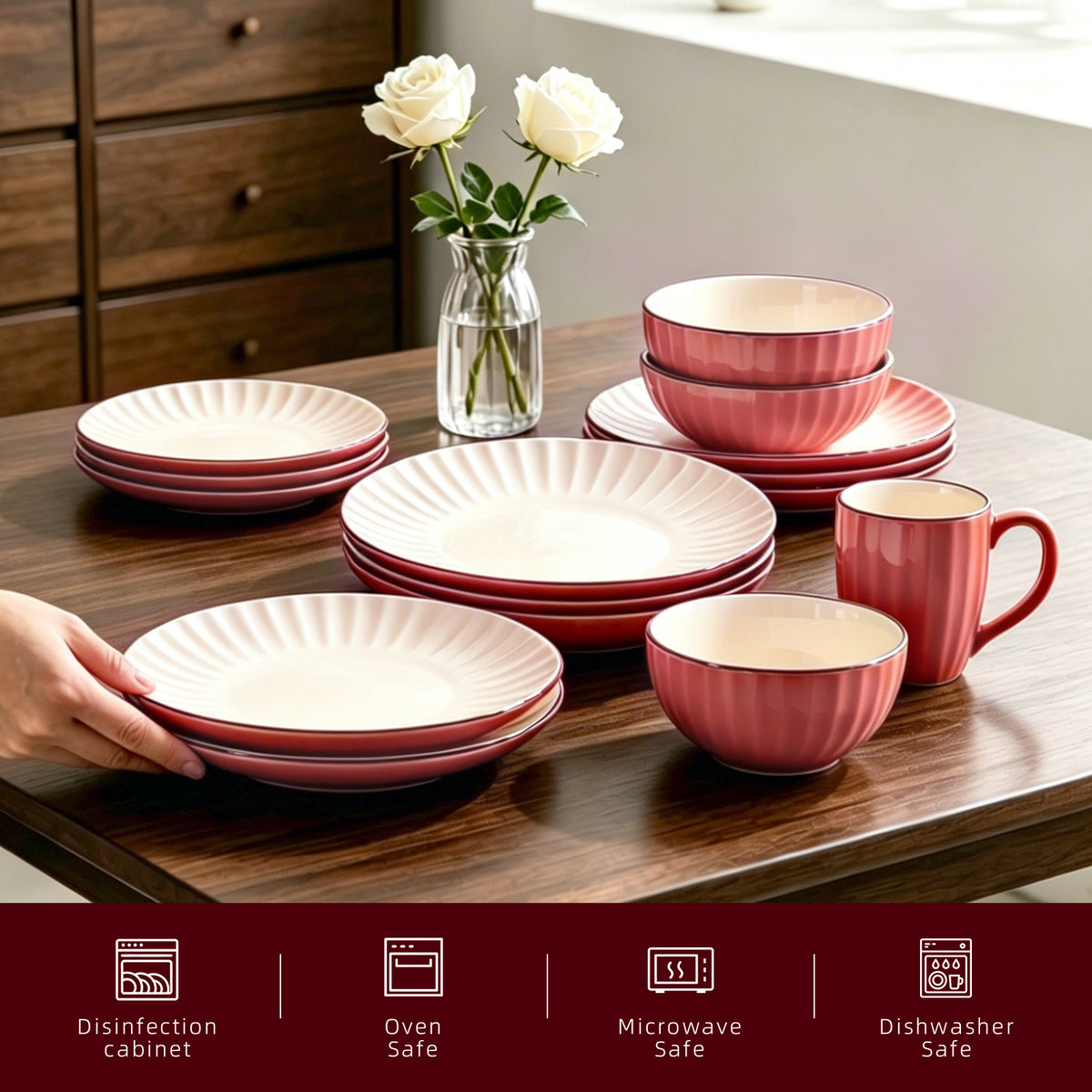 A set of ceramic dinnerware in a muted pink and cream color scheme, displayed on a dark wooden table with a hand holding a stack of plates. A small glass vase with white roses sits in the background, and a dark red banner at the bottom lists dishwasher, oven safe, microwave safe, and disinfection cabinet features.