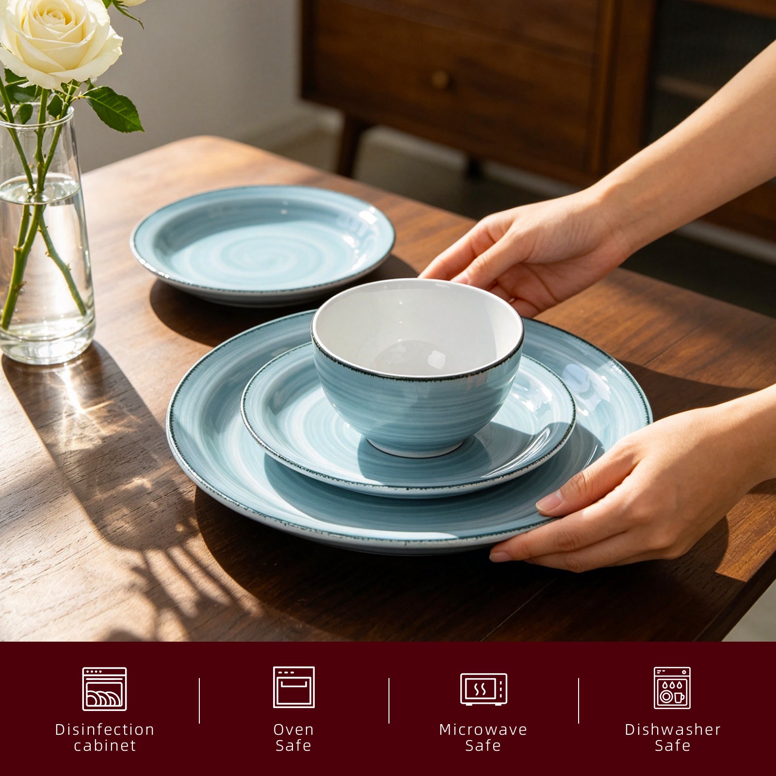 A set of light blue ceramic tableware, including plates and a bowl, arranged on a wooden dining table with a person's hands placing the bowl. A glass vase with a white rose is on the left, and a dark red informational banner at the bottom lists features like disinfection cabinet, oven safe, microwave safe, and dishwasher safe.