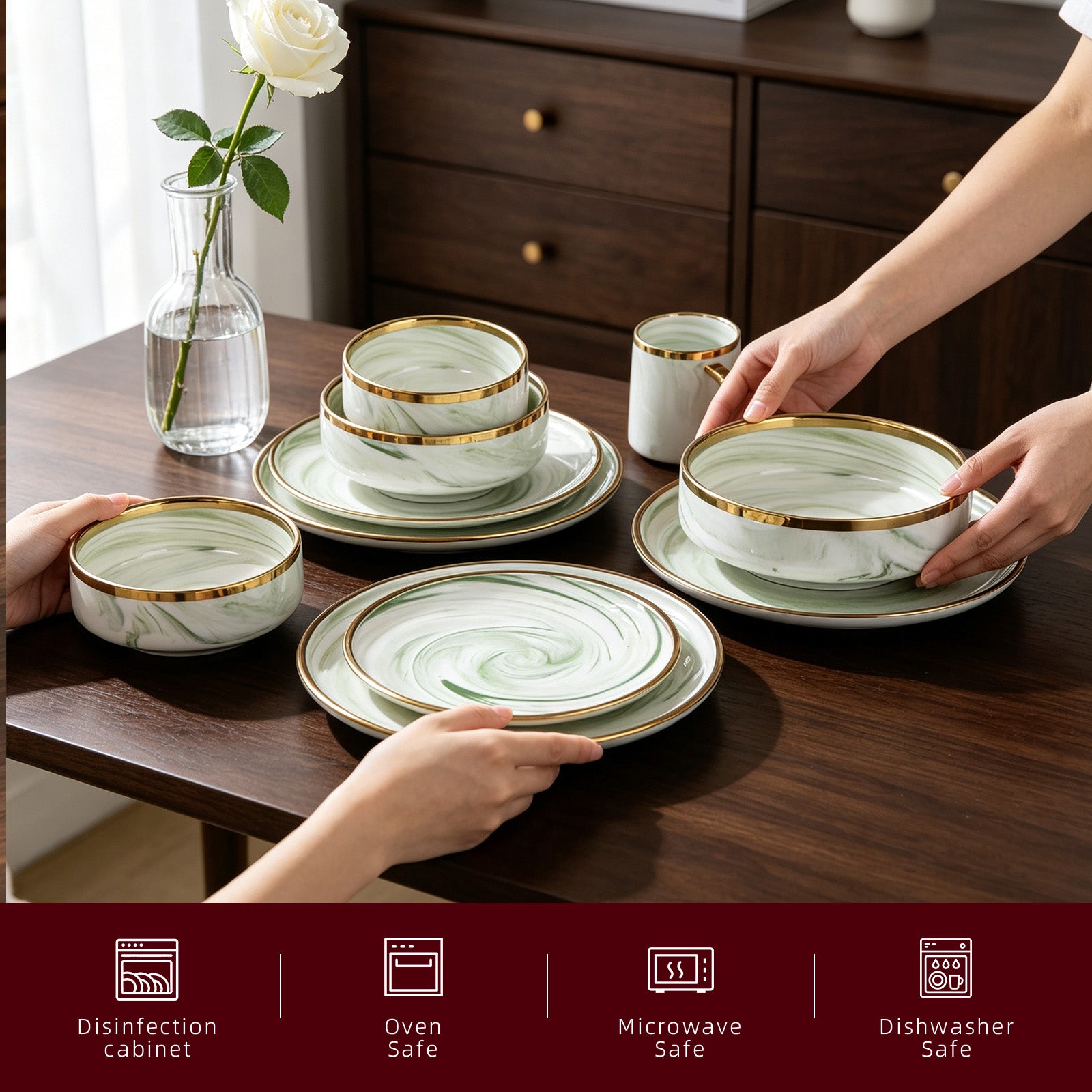 A set of white ceramic dinnerware with a light green marble swirl pattern and gold trim, arranged on a dark wooden dining table. Hands are shown placing the plates and bowls, with a glass vase of a white rose in the background.